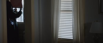 Movie still from “The Independent” (2022), directed by Amy Rice – A window that has blinds on the side of the window; Extreme Close Up shot, Low angle