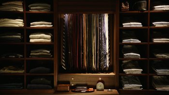 Movie still from “The Intern” (2015), directed by Nancy Meyers – A room with a lot of ties hanging up; Medium shot, Overhead angle