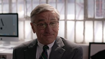 Movie still from “The Intern” (2015), directed by Nancy Meyers – An older man wearing a suit and tie; Close Up shot, Over the shoulder angle