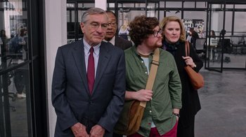 Movie still from “The Intern” (2015), directed by Nancy Meyers – A group of people standing next to each other; Medium shot, Over the shoulder angle