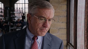 Movie still from “The Intern” (2015), directed by Nancy Meyers – An older man wearing a suit and tie; Close Up shot, Over the shoulder angle