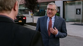 Movie still from “The Intern” (2015), directed by Nancy Meyers – An older man wearing a suit and tie; Medium shot, Over the shoulder angle