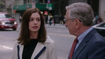 Movie still from “The Intern” (2015), directed by Nancy Meyers – A man and a woman standing next to each other on the street; Close Up shot, Over the shoulder angle