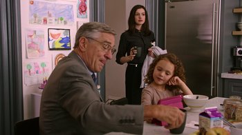 Movie still from “The Intern” (2015), directed by Nancy Meyers – An older man sitting at a table with a young girl and an older woman; Medium shot, Over the shoulder angle