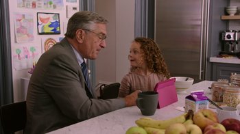 Movie still from “The Intern” (2015), directed by Nancy Meyers – An older man sitting at a table talking to a young girl; Medium shot, Over the shoulder angle