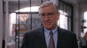 Movie still from “The Intern” (2015), directed by Nancy Meyers – An older man wearing a suit and tie; Close Up shot, Over the shoulder angle