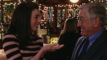 Movie still from “The Intern” (2015), directed by Nancy Meyers – A man and a woman are talking to each other; Medium shot, Over the shoulder angle