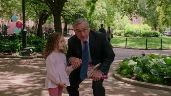 Movie still from “The Intern” (2015), directed by Nancy Meyers – An older man and a young girl are standing in a park; Medium shot, Over the shoulder angle