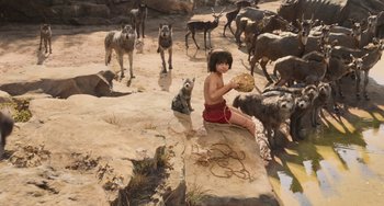 Movie still from “The Jungle Book” (2016), directed by Jon Favreau – A painting of a young boy sitting on a rock surrounded by animals; Wide shot, High angle
