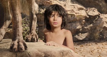 Movie still from “The Jungle Book” (2016), directed by Jon Favreau – A young boy sitting next to a tree trunk; Close Up shot, Low angle