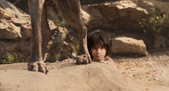 Movie still from “The Jungle Book” (2016), directed by Jon Favreau – A young boy and a large animal on a rock; Medium shot, High angle