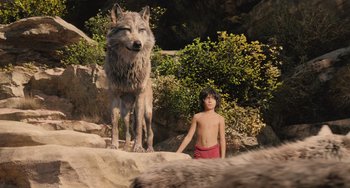 Movie still from “The Jungle Book” (2016), directed by Jon Favreau – A young boy standing next to a wolf; Wide shot, Low angle