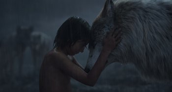 Movie still from “The Jungle Book” (2016), directed by Jon Favreau – A young boy holding onto a wolf's head; Close Up shot, High angle