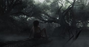 Movie still from “The Jungle Book” (2016), directed by Jon Favreau – A woman sitting on a log in the middle of a forest; Wide shot, Low angle