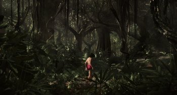 Movie still from “The Jungle Book” (2016), directed by Jon Favreau – A man standing in the middle of a forest; Extreme Wide shot, High angle