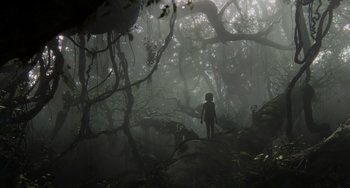Movie still from “The Jungle Book” (2016), directed by Jon Favreau – A person standing in the middle of a dense forest; Extreme Wide shot, Low angle
