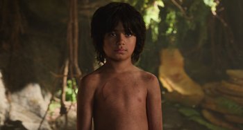 Movie still from “The Jungle Book” (2016), directed by Jon Favreau – A young boy is standing in the woods; Close Up shot, High angle