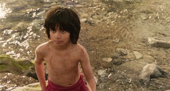 Movie still from “The Jungle Book” (2016), directed by Jon Favreau – A young boy standing in the middle of a river; Medium shot, High angle