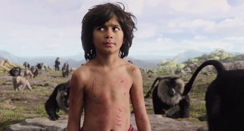 Movie still from “The Jungle Book” (2016), directed by Jon Favreau – A young boy standing in front of a herd of wild animals; Medium shot, Low angle