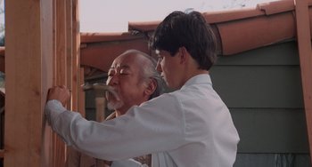 Movie still from “The Karate Kid Part II” (1986), directed by John G. Avildsen – An older man and a younger man in white shirts; Close Up shot, Low angle