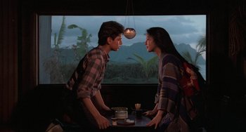 Movie still from “The Karate Kid Part II” (1986), directed by John G. Avildsen – A man and a woman standing in front of each other at a table; Medium shot, Over the shoulder angle