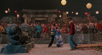 Movie still from “The Karate Kid Part II” (1986), directed by John G. Avildsen – A group of people standing in front of a crowd; Extreme Wide shot, High angle