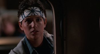 Movie still from “The Karate Kid Part III” (1989), directed by John G. Avildsen – A young man with a bandana on his head looking in a mirror; Close Up shot, Over the shoulder angle