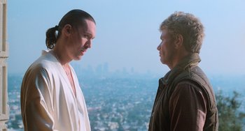 Movie still from “The Karate Kid Part III” (1989), directed by John G. Avildsen – Two men standing next to each other in front of a city; Close Up shot, Low angle