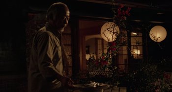 Movie still from “The Karate Kid Part III” (1989), directed by John G. Avildsen – An older man standing in front of a table; Medium shot, Low angle