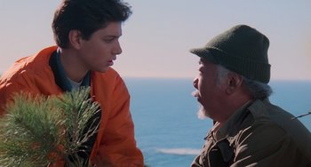 Movie still from “The Karate Kid Part III” (1989), directed by John G. Avildsen – A man and a young boy talking to each other near the ocean; Close Up shot, Over the shoulder angle