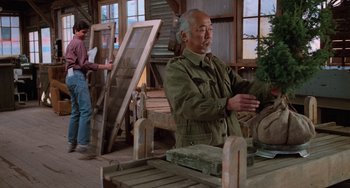 Movie still from “The Karate Kid Part III” (1989), directed by John G. Avildsen – An older man is working in a wood shop; Medium shot, Over the shoulder angle