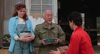 Movie still from “The Karate Kid Part III” (1989), directed by John G. Avildsen – An older man is holding a book in his hands; Medium shot, Over the shoulder angle