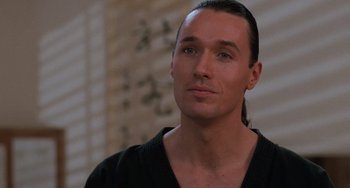 Movie still from “The Karate Kid Part III” (1989), directed by John G. Avildsen – A person with long black hair; Close Up shot, Low angle