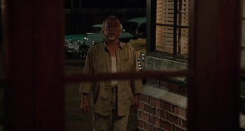 Movie still from “The Karate Kid Part III” (1989), directed by John G. Avildsen – An older man standing in front of a brick building; Medium shot, Over the shoulder angle