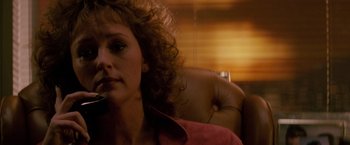 Movie still from “Die Hard” (1988), directed by John McTiernan – A person sitting in a chair holding a cell phone; Close Up shot, Low angle