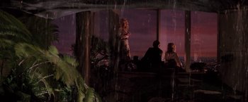 Movie still from “Die Hard” (1988), directed by John McTiernan – A group of people sitting at a table in front of a window; Wide shot, High angle