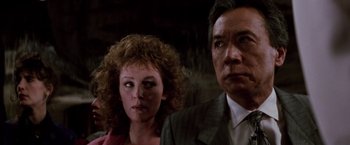 Movie still from “Die Hard” (1988), directed by John McTiernan – A man and a woman standing next to each other; Close Up shot, Low angle