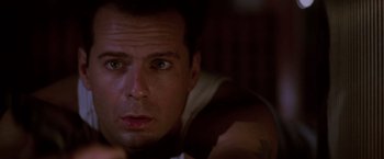 Movie still from “Die Hard” (1988), directed by John McTiernan – A person looking at the camera; Close Up shot, Low angle