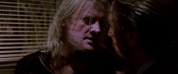 Movie still from “Die Hard” (1988), directed by John McTiernan – A man with long blonde hair looking into a mirror; Close Up shot, Over the shoulder angle