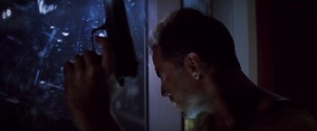 Movie still from “Die Hard” (1988), directed by John McTiernan – A person holding a gun in his hand; Close Up shot, Low angle
