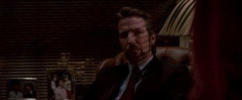 Movie still from “Die Hard” (1988), directed by John McTiernan – A person wearing a suit and tie; Close Up shot, Low angle