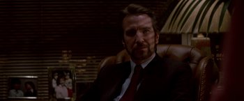 Movie still from “Die Hard” (1988), directed by John McTiernan – A person wearing a suit and tie; Close Up shot, Low angle