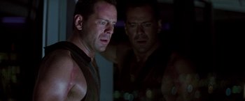 Movie still from “Die Hard” (1988), directed by John McTiernan – A man looking at himself in the mirror; Close Up shot, Low angle