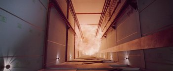 Movie still from “Die Hard” (1988), directed by John McTiernan – An image of a fire in a building that is going through the ceiling; Extreme Wide shot, Overhead angle