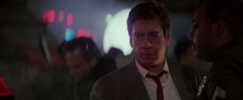 Movie still from “Die Hard” (1988), directed by John McTiernan – A person wearing a suit and tie; Close Up shot, Low angle