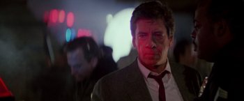 Movie still from “Die Hard” (1988), directed by John McTiernan – A person wearing a suit and tie; Close Up shot, Low angle
