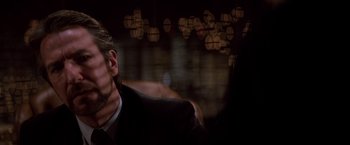 Movie still from “Die Hard” (1988), directed by John McTiernan – A man in a black suit is looking into the distance; Close Up shot, Over the shoulder angle