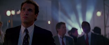 Movie still from “Die Hard” (1988), directed by John McTiernan – A group of men in suits standing in front of a projector; Close Up shot, Low angle