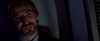 Movie still from “Die Hard” (1988), directed by John McTiernan – A person wearing a suit and tie; Close Up shot, Low angle