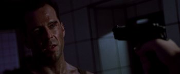 Movie still from “Die Hard” (1988), directed by John McTiernan – A person with a gun in a dark room; Close Up shot, Low angle